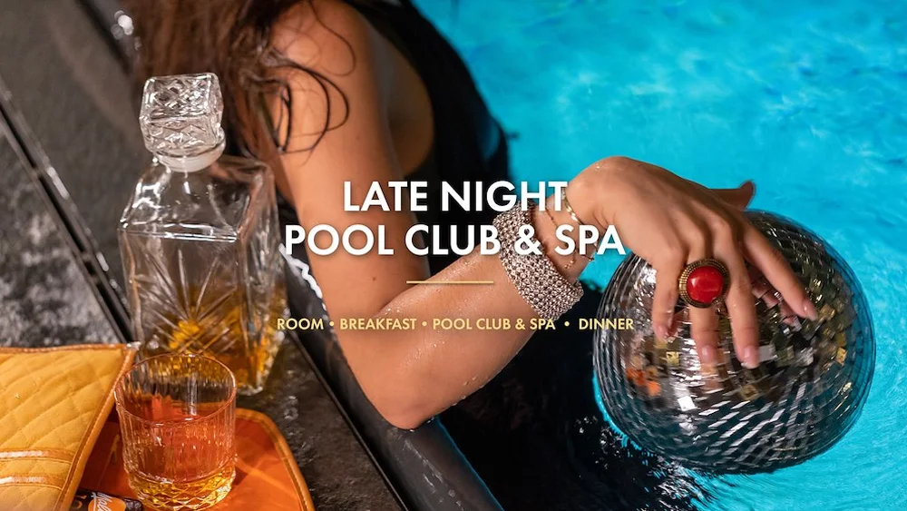 Kvinna i pool på Jacy’z håller i en discokula. Drinkglas står på poolkanten i bakgrunden.