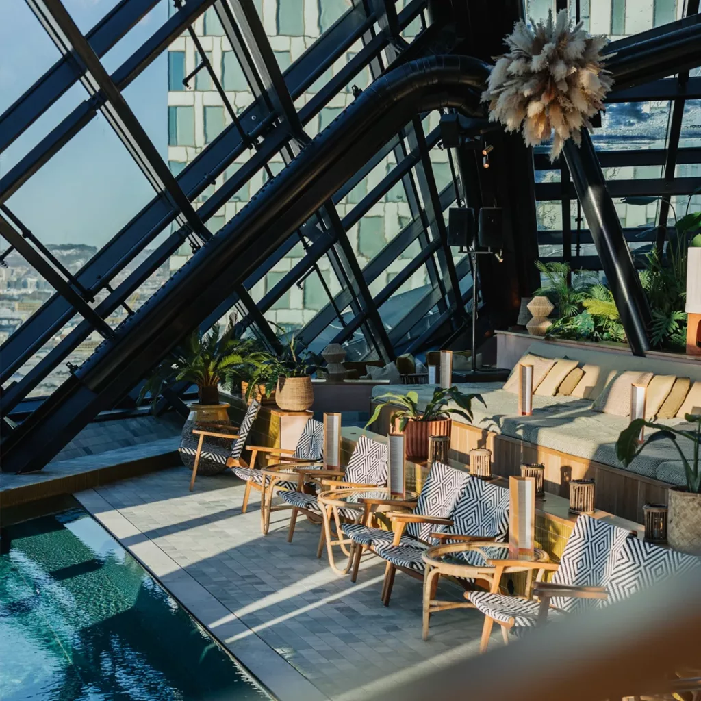 Lyxig inomhuspool på Jacy’z Spa med utsikt över Göteborg. Solen strålar in genom fönstret och skapar en spektakulär atmosfär.