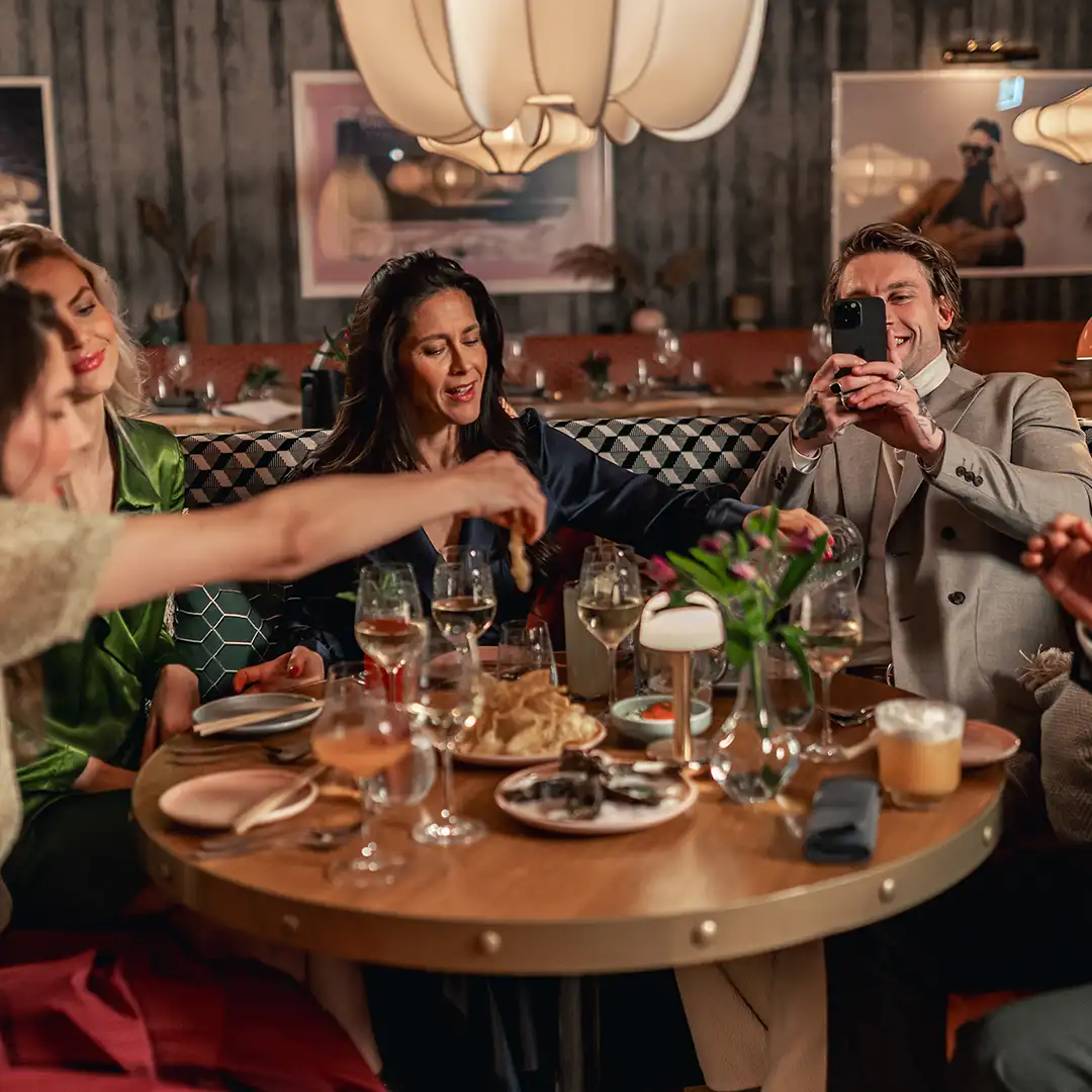 Grupp vänner som njuter av middag och skratt på Jacy’z Hotel i Göteborg.